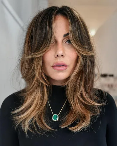 Try on this trendy long wavy hairstyle with subtle highlights