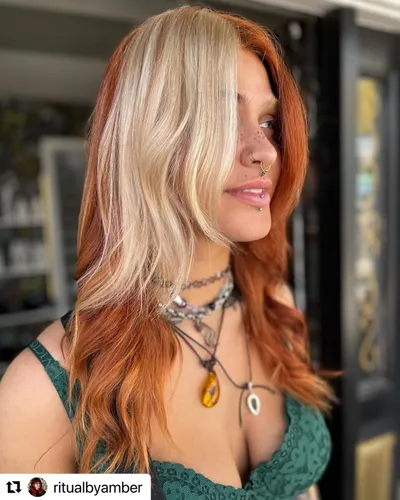 Try on this stylish hairstyle featuring straight, two-tone hair with prominent contrasting colors of blonde on one side and red on the other, providing a striking and trendy look.