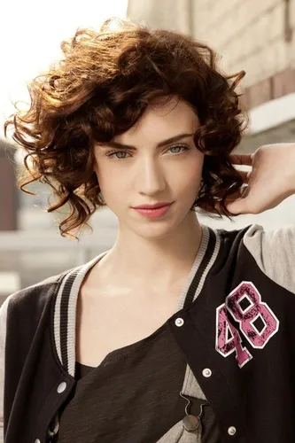 Try on this curly hairstyle featuring voluminous, bouncy curls that add a playful and dynamic look to one's appearance.