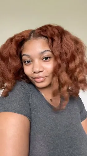 Try on a medium-length curly hairstyle with reddish-brown color.