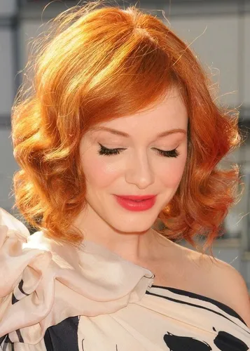 Try on a glamorous hairstyle featuring lush, curly, red hair framing the face, swept slightly to the side for a soft, elegant look.