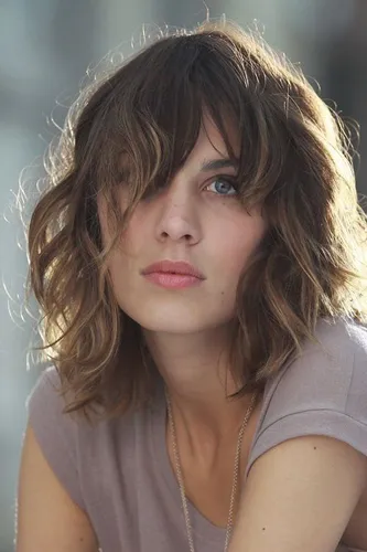 Try on a medium wavy hairstyle for a relaxed and casual look. The hair is shoulder-length with natural waves, giving it a carefree and easy-going vibe.