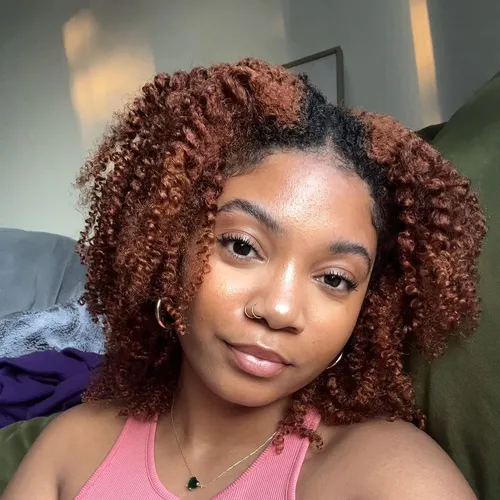 Try on a shoulder-length curly hairstyle in shades of natural brown and auburn.