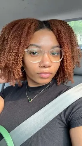 Try on this shoulder-length, tightly coiled curly hairstyle in shades of brown and auburn.