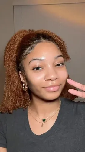 Try on a medium-length curly hairstyle, highlighting loose, voluminous curls gathered to one side.