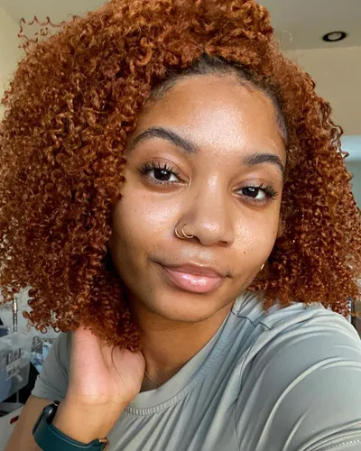 try on a voluminous shoulder-length curly hairstyle in a vibrant auburn shade.