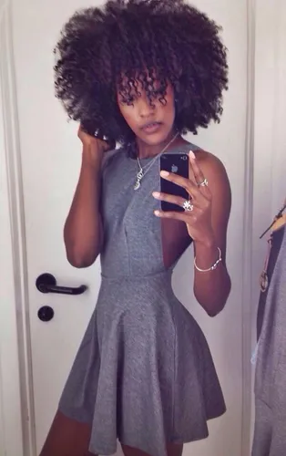 Try on a voluminous curly hairstyle as seen on the woman facing forward in the image.