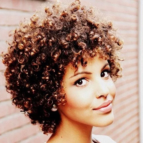 Try on a short, curly hairstyle featuring tightly coiled curls with abundant volume and texture.