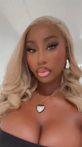 try on this glamorous wavy blonde hairstyle that falls elegantly around the shoulders, paired with darker roots for a stylish contrast