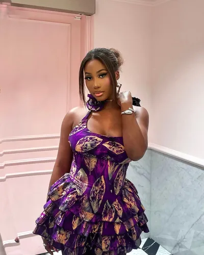 Try on a high bun hairstyle, featuring a neat bun positioned at the top of the head, complemented by a few loose strands framing the face