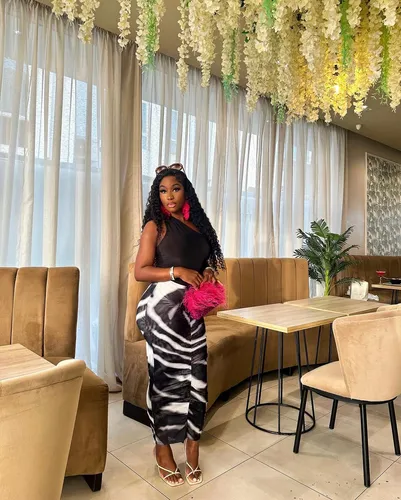 Try on this long, wavy hairstyle that drapes elegantly, complemented by a pair of bold pink earrings adding a pop of color