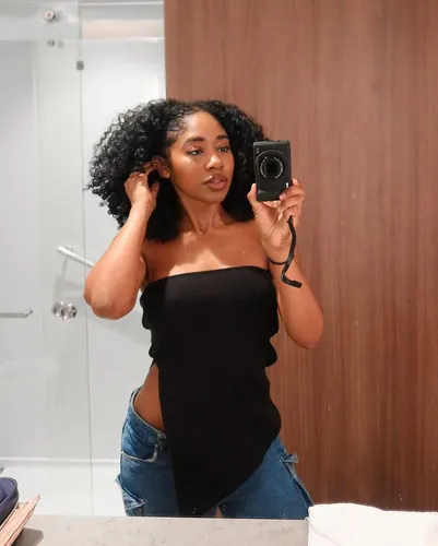 Try on a hairstyle featuring long, voluptuous curly hair, projected as perfectly styled for a glamorous look.