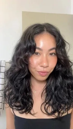 Try on this black curly hairstyle, featuring voluminous curls that frame the face beautifully.