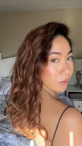 try on this hairstyle featuring long wavy hair with natural highlights reflecting the sunlight