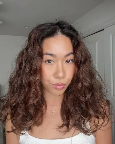 Try on this medium-length, wavy hairstyle with rich brown tones, adding a lively texture and volume.