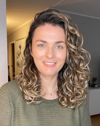 Try on this voluminous medium-length curly hairstyle, featuring rich, defined curls