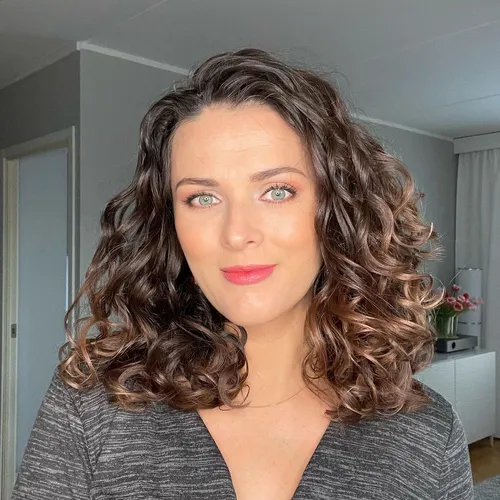 Try on this hairstyle showcasing medium-length curly hair with distinct ringlet curls tumbling down gracefully.