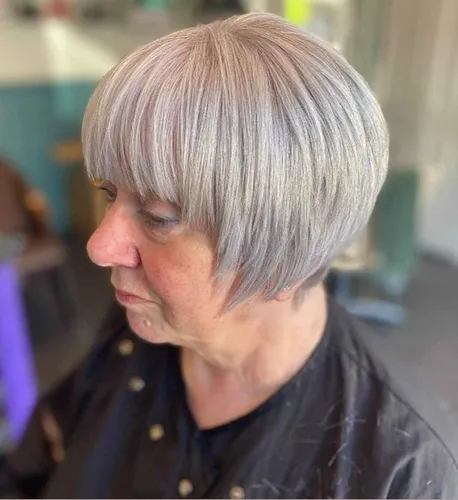Try on this sleek short bob hairstyle with a captivating silver shade, styled neatly around the head.