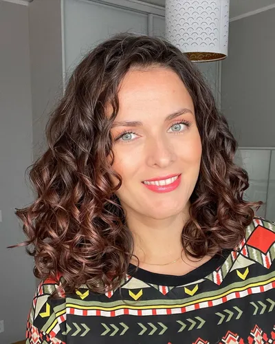Try on this hairstyle featuring medium-length curly hair with subtle highlights, giving a vibrant and textured appearance.