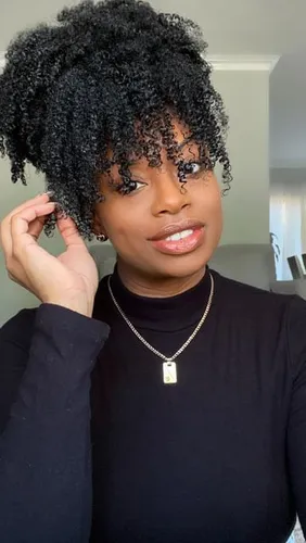 Try on a hairstyle featuring tight curls, with the hair piled on top and intricately defined curls hanging down around the face.