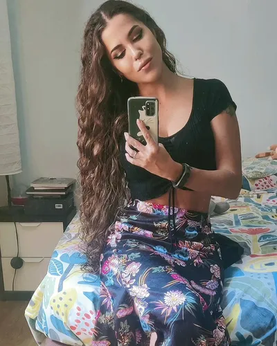 Try on this long, wavy hairstyle showcased by the person taking a selfie. The hair is voluminous with luxurious curls, flowing over the shoulders.