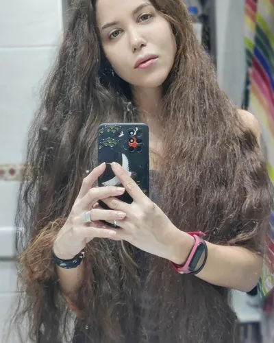 Try on this long, wavy hairstyle, featuring voluminous, tousled locks that cascade past the shoulders, creating a relaxed and casual look.