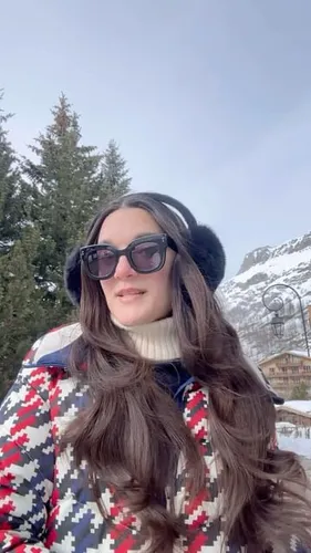 Try on a long wavy hairstyle with a winter hat in a snowy environment