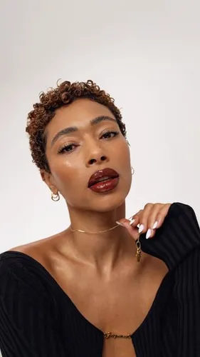 Try on a short curly hairstyle, featuring tight, well-defined curls that add volume around the head.