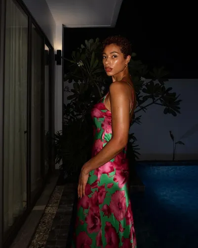 Try on a natural short curly hairstyle with tightly coiled curls, perfect for a sophisticated and stylish look.