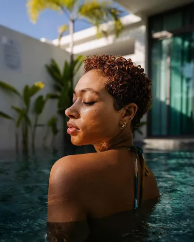 Try on a short curly hairstyle as seen on the woman with her face turned slightly to the side