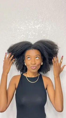 Try on a hairstyle featuring voluminous afro puffs positioned symmetrically on either side of the head, creating a playful and stylish look.