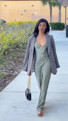 Try on a hairstyle featuring long straight black hair as demonstrated by the woman walking on a sidewalk.