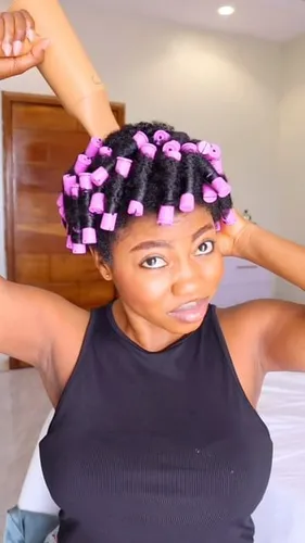 Try on a vibrant curly hairstyle with pink rollers adding a playful touch.