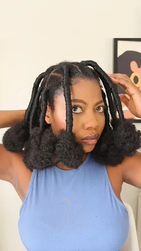 Try on a hairstyle featuring thick twists coupled with voluminous, textured natural hair puffs on sides