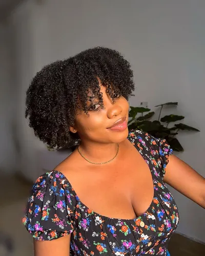 Try on this medium-length curly hairstyle, featuring tight curls that add a bouncy and voluminous look.