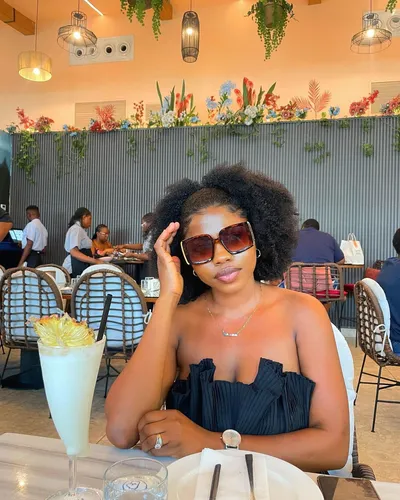 Try on a voluminous afro hairstyle, which appears natural and well-maintained, adding a classic touch to the overall look.