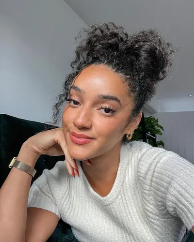 Try on a curly hair styled into a casual high bun, providing a simple yet charming look.