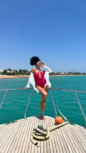 Try on short, curly hair while posing on a boat deck, with a natural outdoor setting in the background.