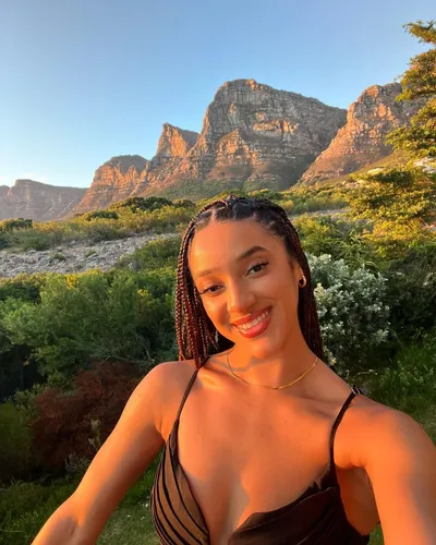 Try on a long braided hairstyle in this image featuring a smiling woman with braided hair.