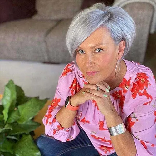 Try on this stylish short, silver-gray hairstyle that features a smoothly tapered shape and a neatly styled side part.
