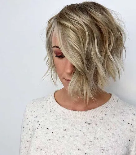 Try on this stylish wavy bob haircut if you're seeking a trendy and vivacious look. The haircut features a dynamic blend of blonde tones that add a lively contrast, enhancing the overall playful yet chic vibe of the style.