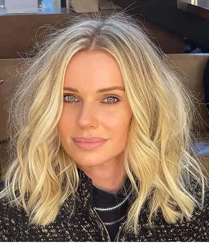 Try on this wavy blonde hairstyle featuring medium-length hair with highlighted strands.