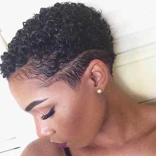 Try on this short curly hairstyle that features neatly tapered sides and natural curls on top.