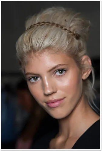 Try on this elegant updo hairstyle featuring a braid wrapped around the crown, adding a chic touch to the messy bun at the back.