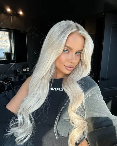 Try on this long, wavy platinum blonde hairstyle that cascades past the shoulders with a glossy, voluptuous look.