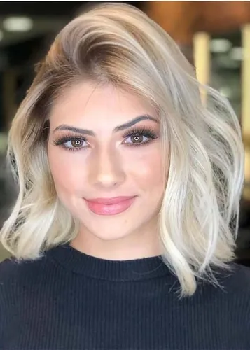 Try on this medium-length wavy blonde hairstyle, styled with soft waves that frame the face beautifully, adding a touch of elegance and femininity.