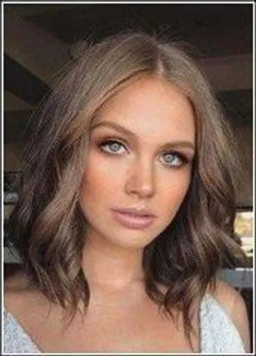 Try on this medium length wavy hairstyle, featuring loosely curled locks that gently frame the face, enhancing a soft and natural look.