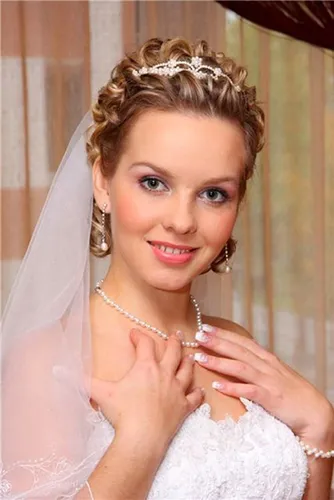 Try on this elegant braided updo accented with a sparkling tiara, perfect for a bridal look.