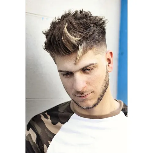 Try on this textured and highlighted hairstyle, featuring short sides with a longer, voluminous top that includes streaks of blonde highlights and a casually tousled appearance.