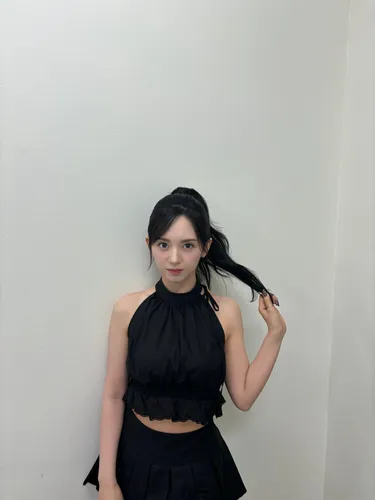 Try on this hairstyle featuring long hair with loose waves, pulled forward over one shoulder with part of it held in her hand, emphasizing its length and texture.